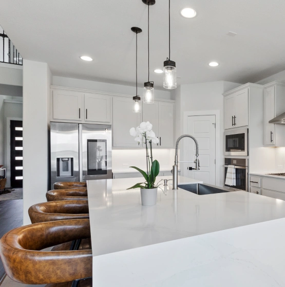 White kitchen island with leather stools and pendant lighting. Kitchen Remodel in Pflugerville, TX.