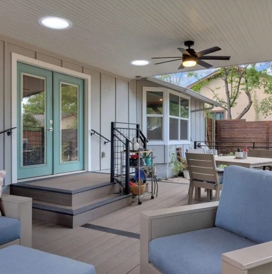 Outdoor covered deck with blue furniture and ceiling fan