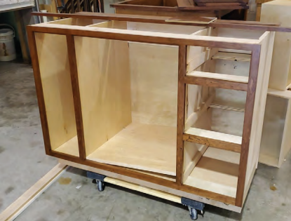 A cabinet is being assembled on a mobile cart in a workshop setting. Bathroom renovation project in Buda, TX.