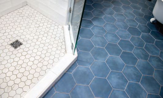 Blue hexagon tile flooring in a bathroom, creating a modern and stylish aesthetic. Bathroom renovation project in Buda, TX.