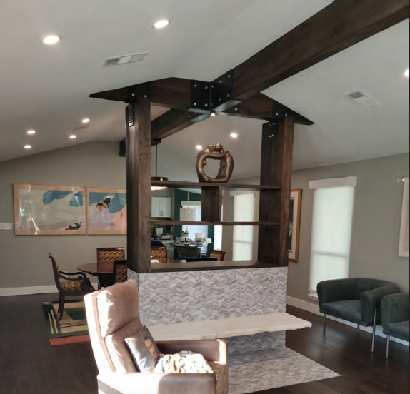 Open-plan living space with a wooden beam structure, built-in shelving, and a herringbone tile backsplash separating areas.  Dining and Living Room Renovation in Austin, TX.