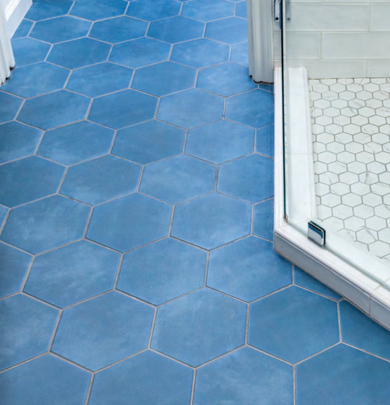 Blue tile floor in a bathroom featuring a shower, creating a clean and modern aesthetic. Bathroom renovation project in Buda, TX.